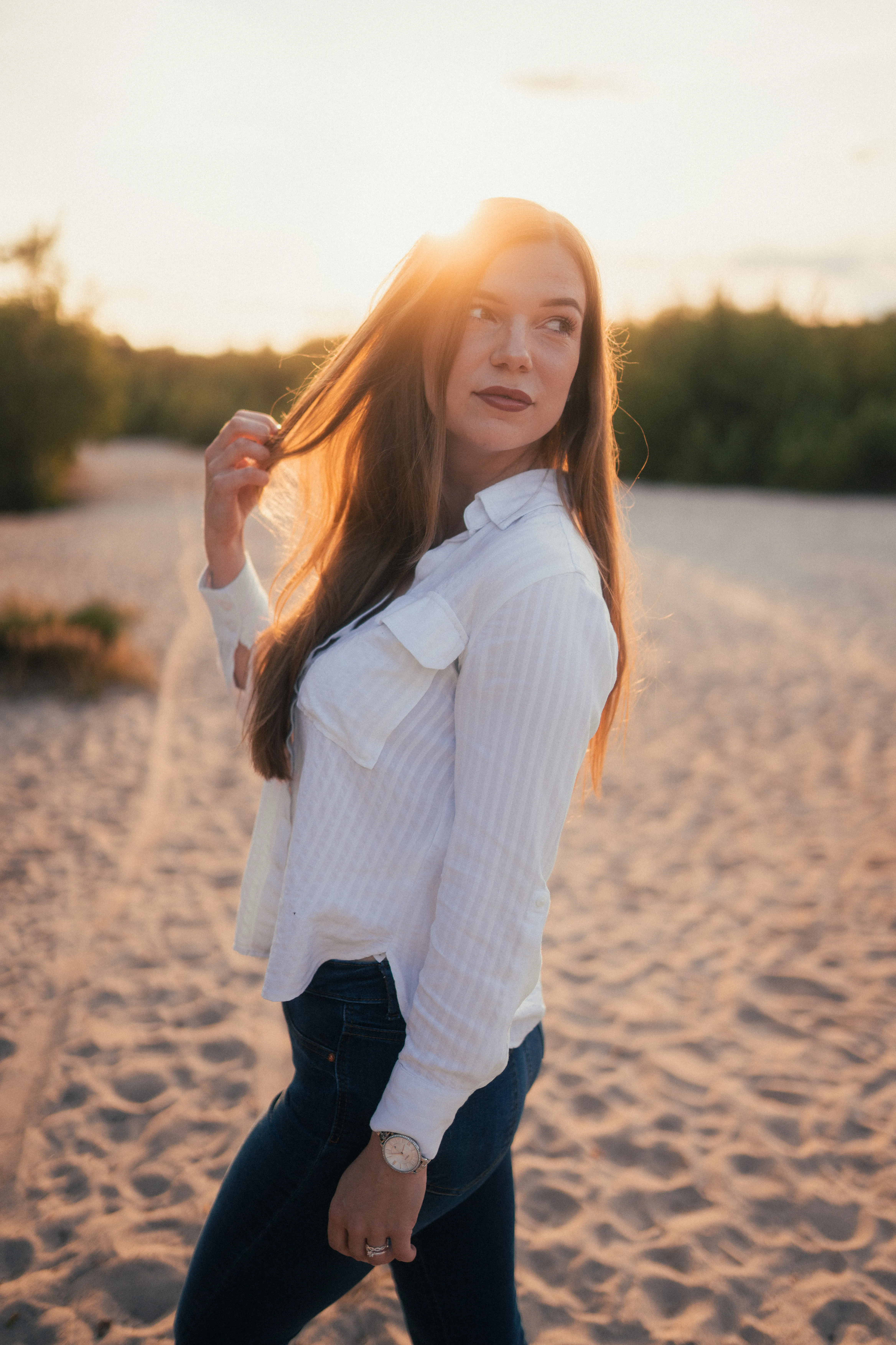 Portrait einer Frau im Gegenlicht der Abendsonne am Strand