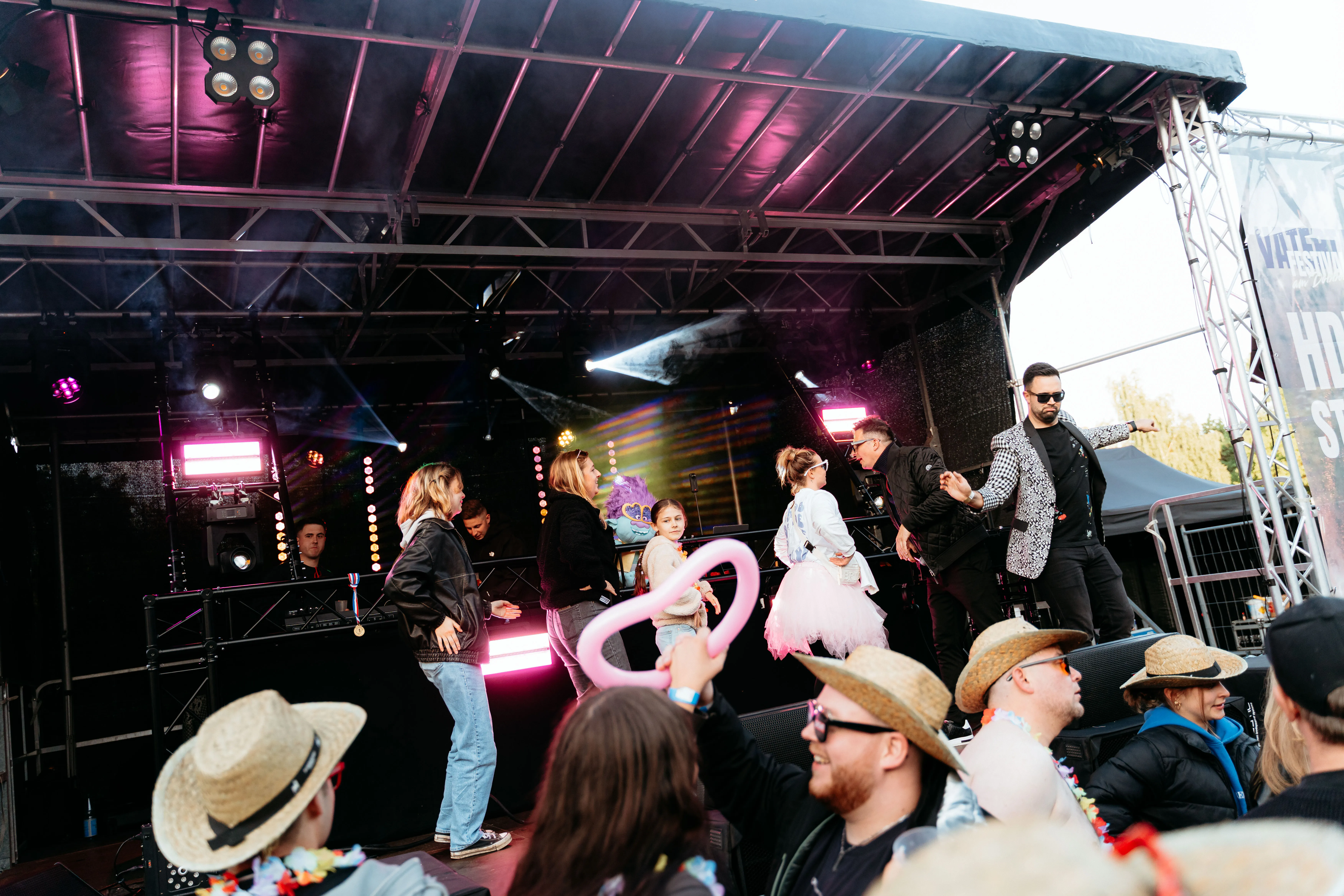 Band auf einer Open-Air-Bühne vor feierndem Publikum